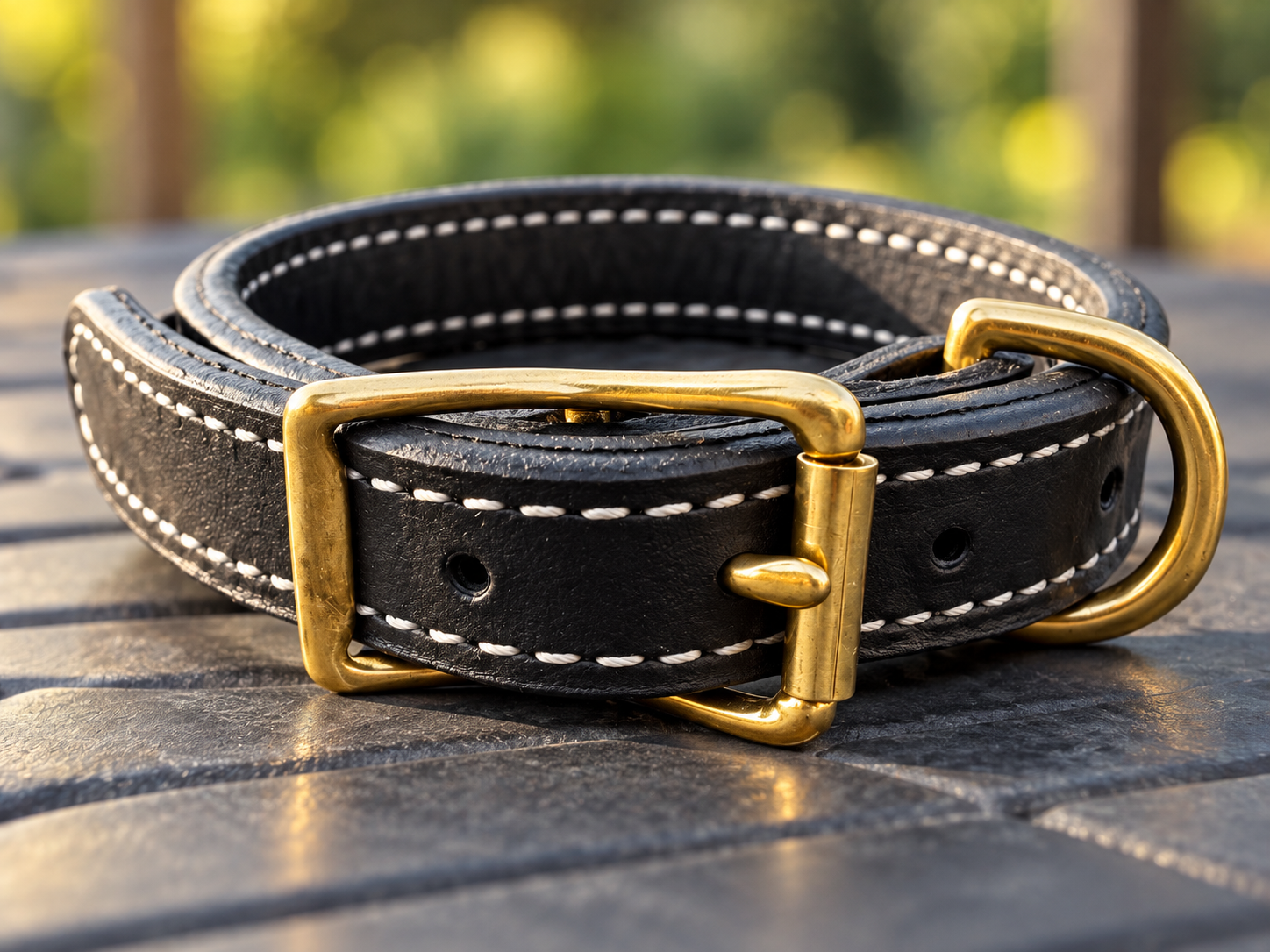 Close-up of buckle, adjustment holes and D-ring on black leather working collar