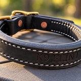 Back of black leather working collar showing K9 FLINT engraving and white stitching
