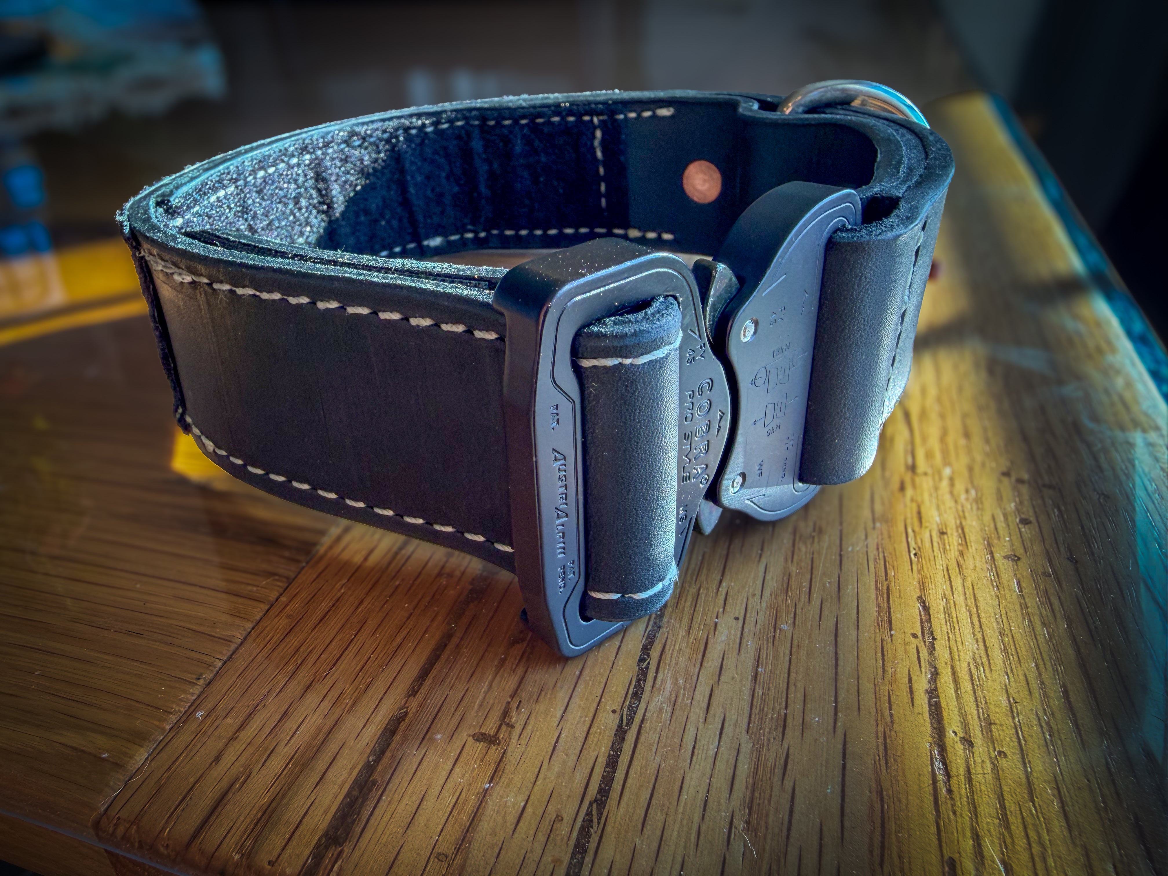 Angled view of black leather COBRA collar with contrasting stitching and quick-release buckle