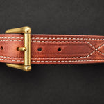 The Young Brand EDC Belt front brass buckle and leather stitching on black studio background